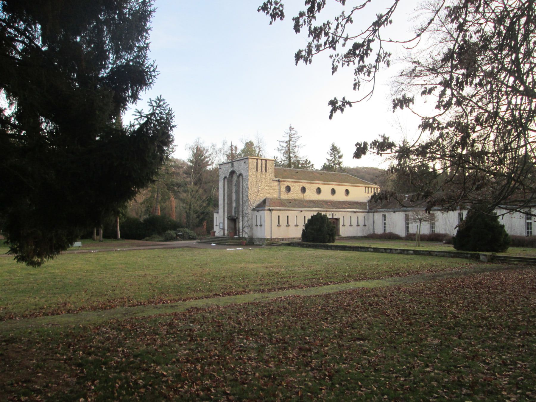 Alte Einsegnungshalle hinter einer weiten Rasenfläche auf Hauptfriedhof Saarbrücken